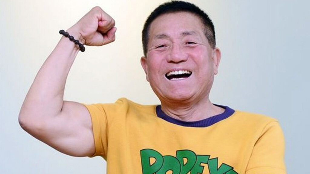 뽀빠이 이상용의 인생스토리 팔을 번쩍 들며 웃고 있는 노년 남성, 건강하고 활기찬 모습